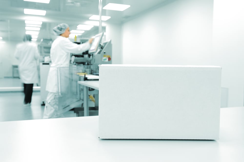 White box at automated production line at modern factory, people working in background