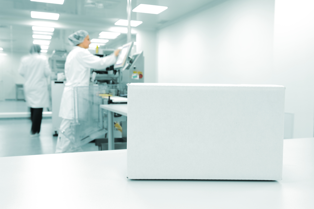 White box at automated production line at modern factory, people working in background
